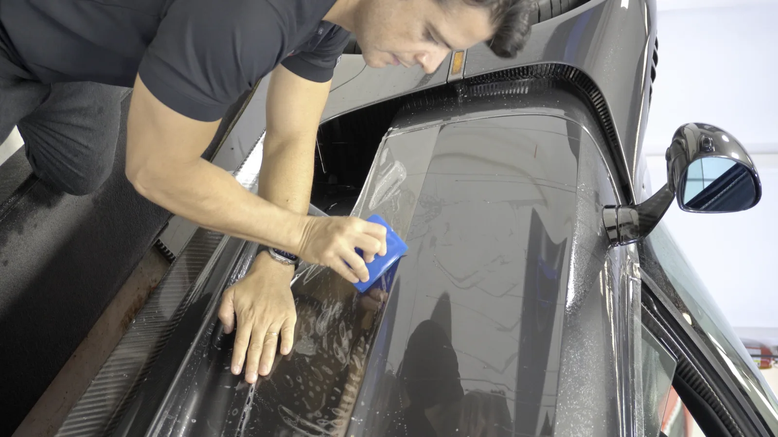 Technician squeegeeing paint protection film by hand